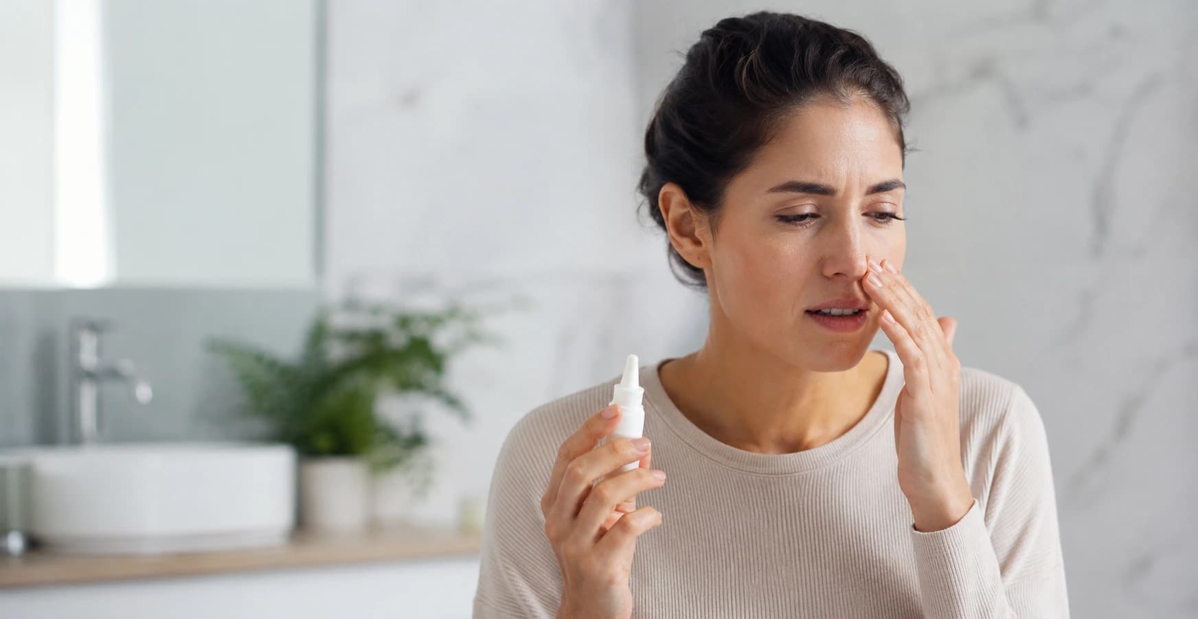 Woman with nasal spray in modern bathroom